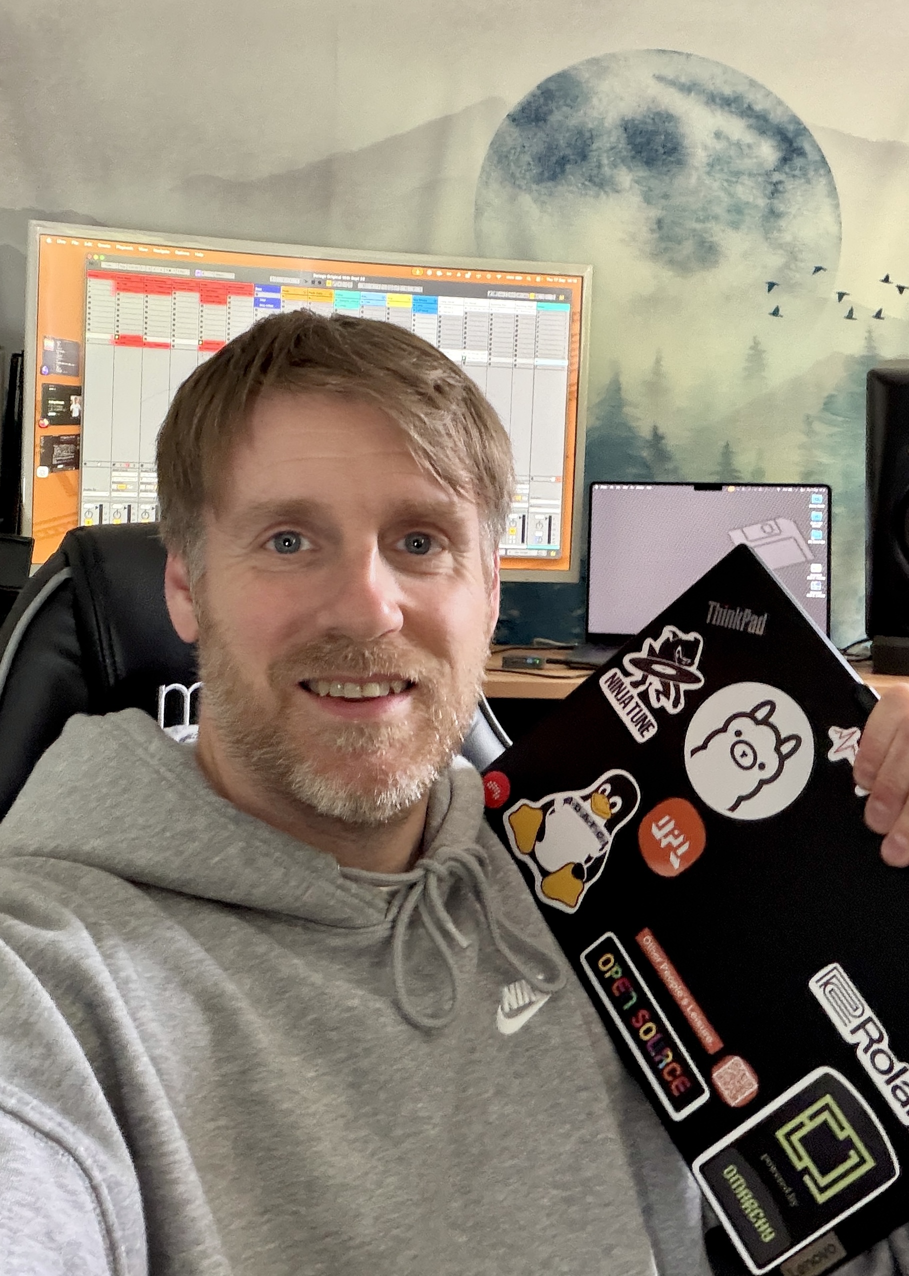 Me in my studio holding my Omarchy-configured ThinkPad.